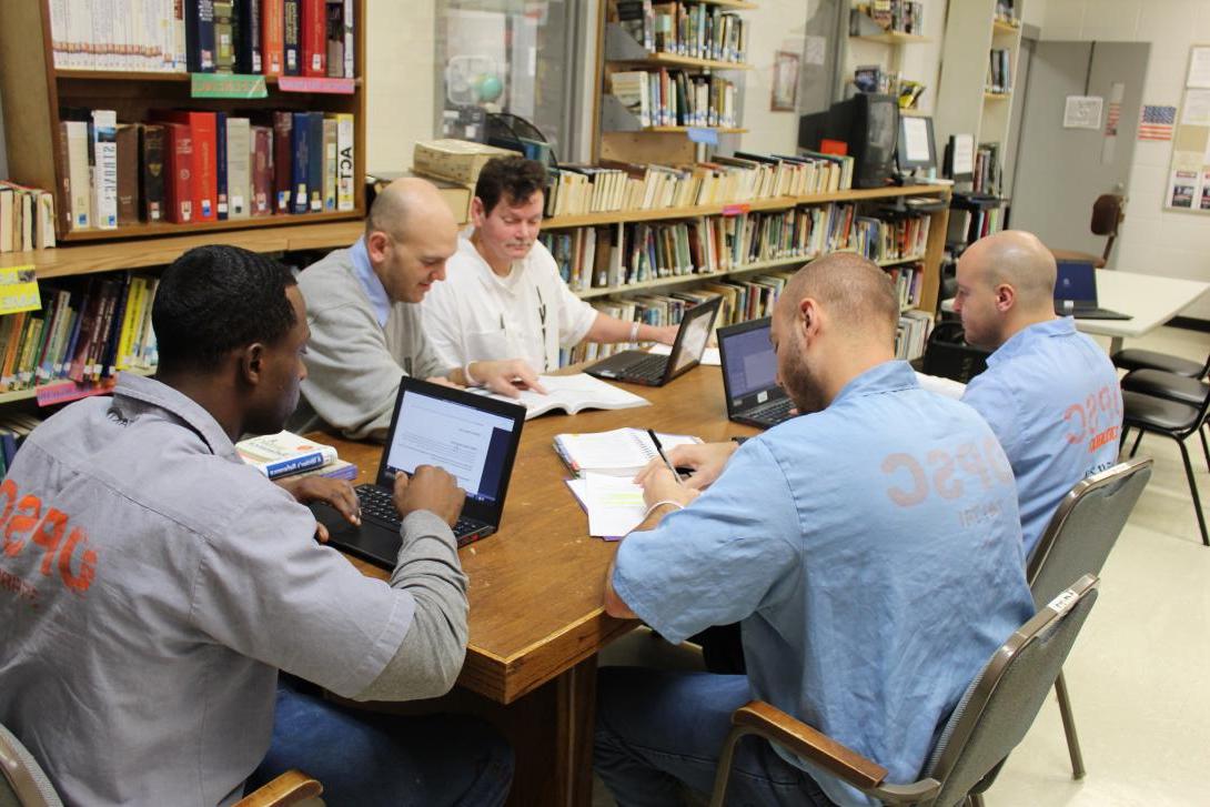 Correctional education students at Rayburn sit around a table studying